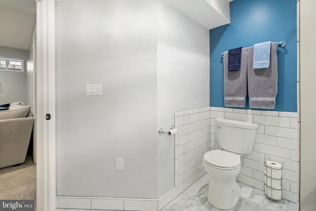 bathroom with tile walls and toilet