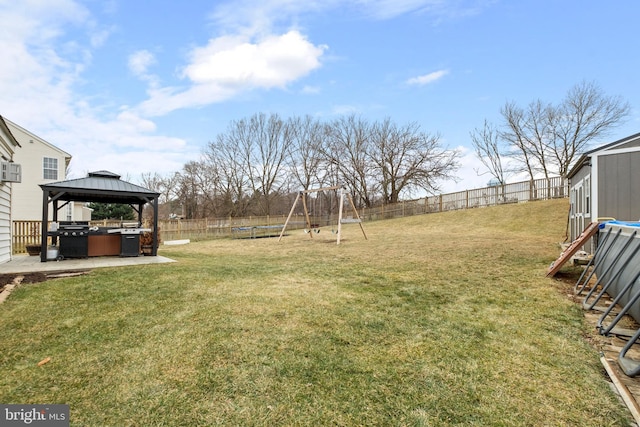 view of yard featuring a trampoline, a gazebo, and a playground