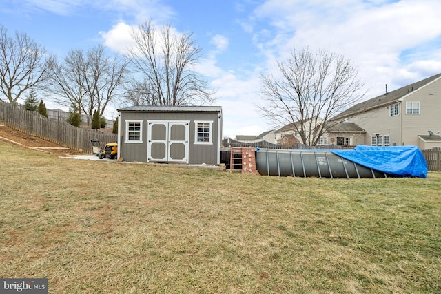 view of yard featuring a covered pool and a storage shed