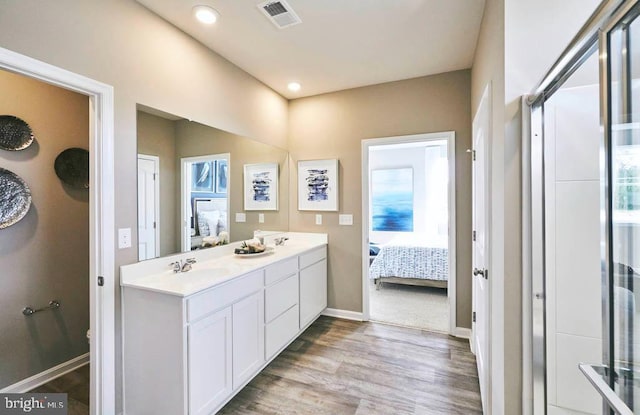 bathroom featuring hardwood / wood-style floors, vanity, and walk in shower