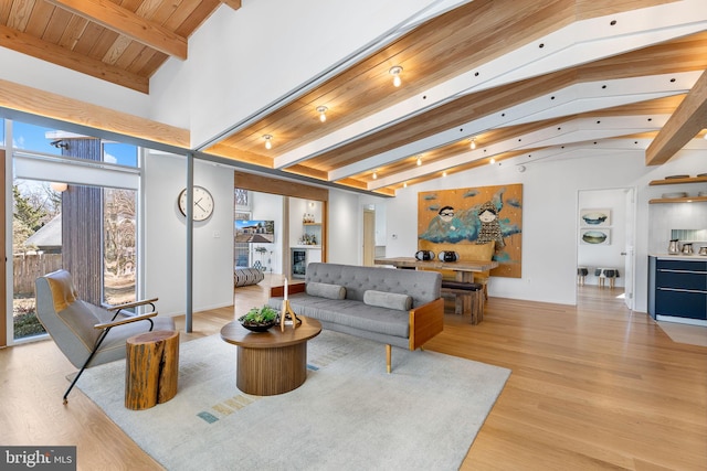 living area featuring wooden ceiling, light wood finished floors, high vaulted ceiling, and beam ceiling