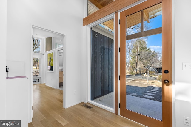 doorway to outside with wood finished floors, visible vents, and baseboards