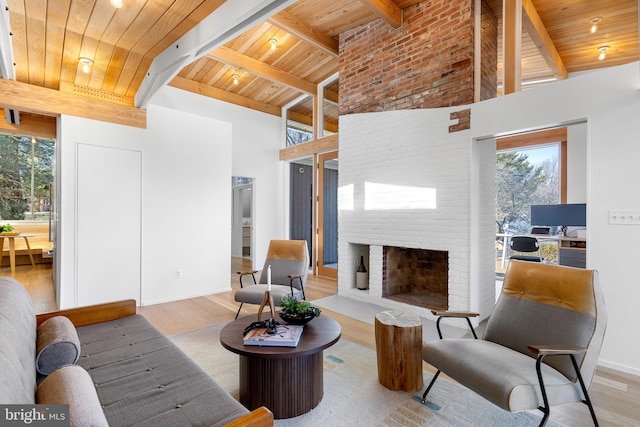 living room featuring high vaulted ceiling, a fireplace, wood finished floors, and wood ceiling