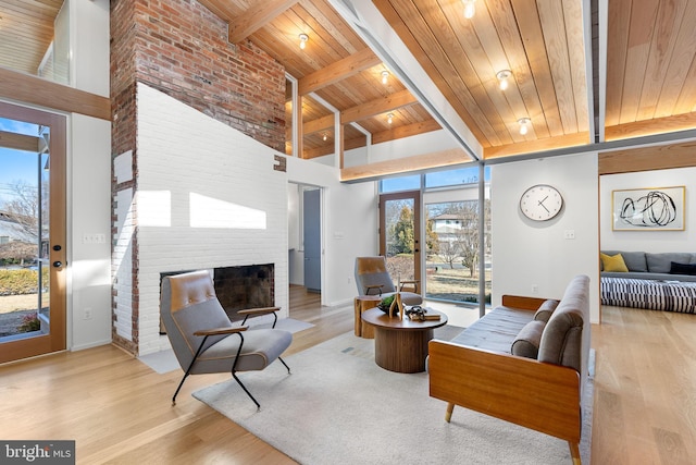 living area with high vaulted ceiling, a fireplace, wooden ceiling, and wood finished floors