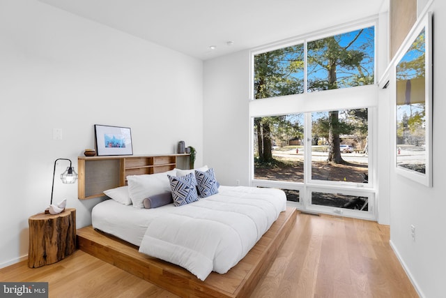 bedroom with baseboards and wood finished floors