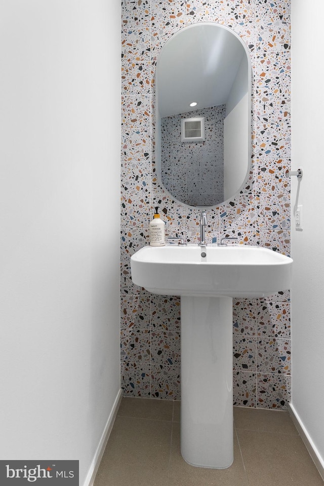 bathroom featuring tile patterned flooring, a sink, and baseboards