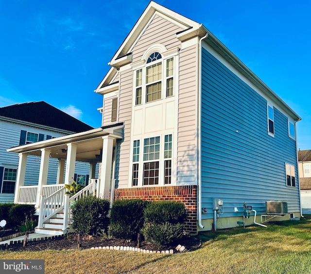 view of property exterior with a porch, a yard, and cooling unit