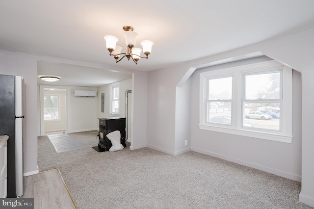 unfurnished living room with light carpet, a notable chandelier, and an AC wall unit