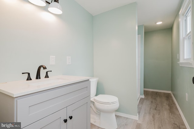 bathroom featuring hardwood / wood-style flooring, vanity, and toilet