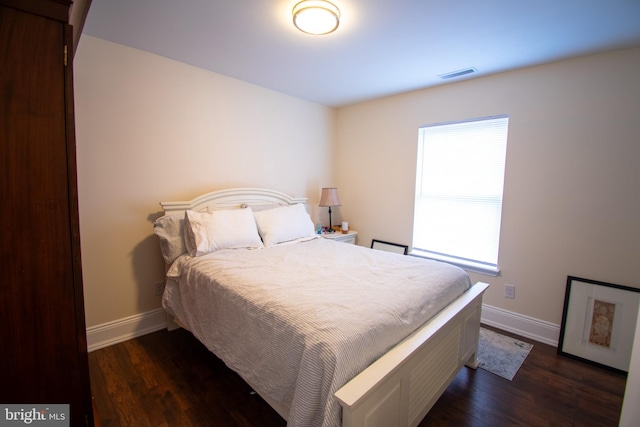 bedroom with baseboards, visible vents, and dark wood-style flooring