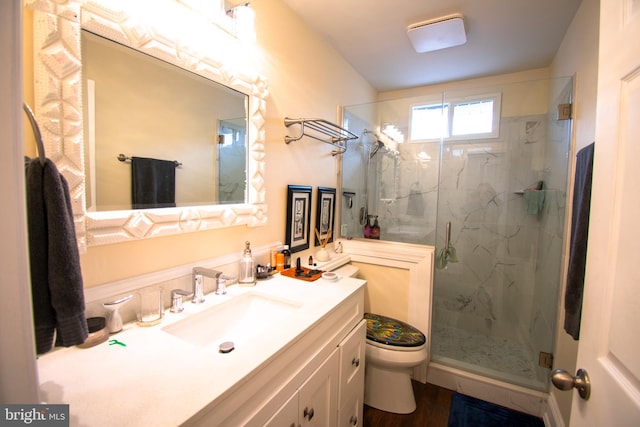 bathroom featuring wood-type flooring, vanity, toilet, and walk in shower