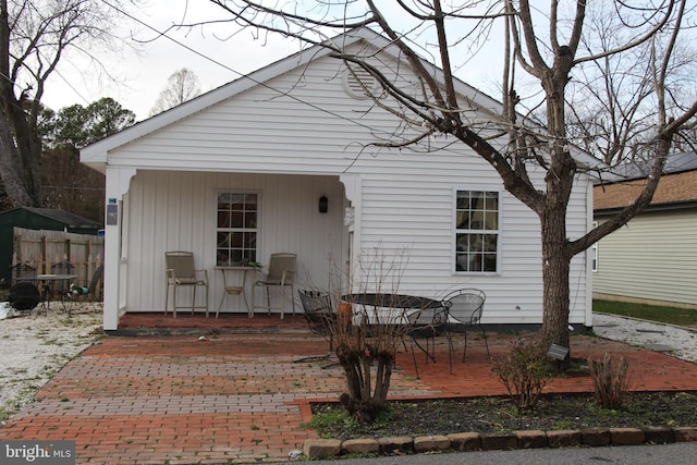 view of front of home featuring a patio area and fence