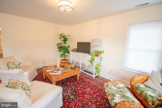 living room with baseboards and visible vents