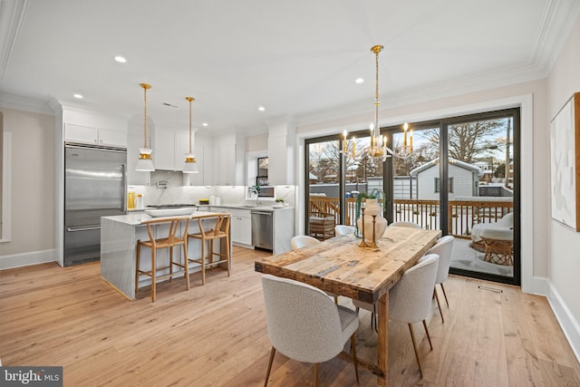 dining space featuring ornamental molding, a wealth of natural light, and light hardwood / wood-style flooring