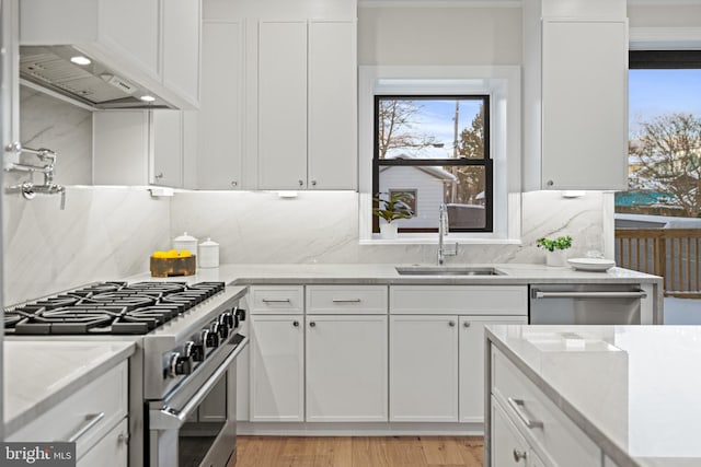 kitchen featuring white cabinets, light stone counters, sink, and appliances with stainless steel finishes