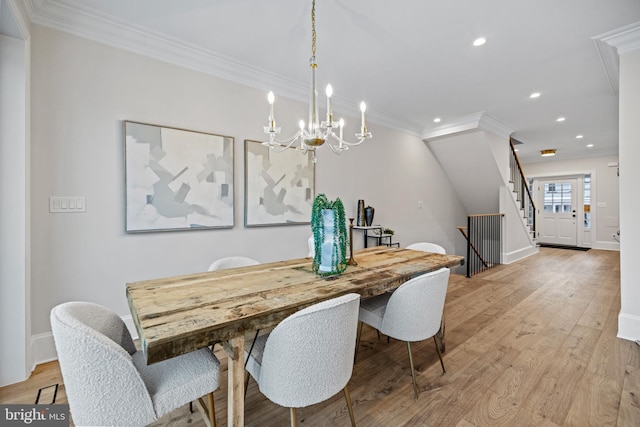 dining room with light hardwood / wood-style flooring, a chandelier, and ornamental molding