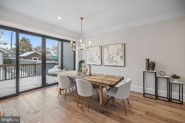 dining space featuring hardwood / wood-style flooring, an inviting chandelier, and ornamental molding