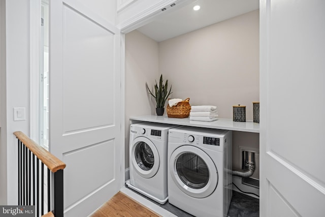 laundry area with washing machine and dryer and light hardwood / wood-style flooring