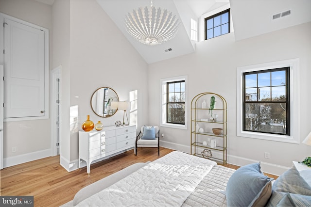 bedroom with hardwood / wood-style floors, high vaulted ceiling, and multiple windows