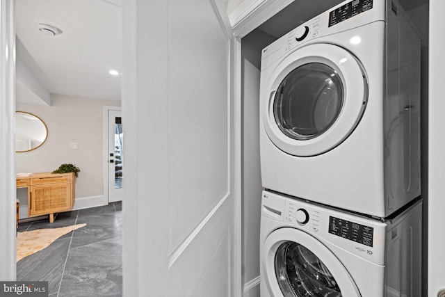 clothes washing area featuring stacked washer and clothes dryer