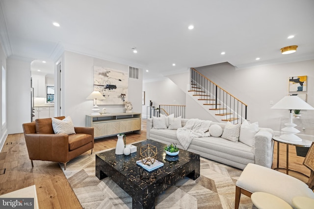 living room featuring light wood-type flooring and crown molding