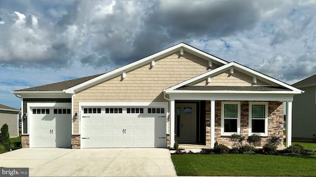 craftsman-style house featuring a garage and a front lawn