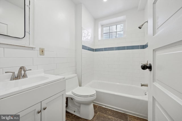 full bathroom with vanity, toilet, tile walls, and tiled shower / bath combo