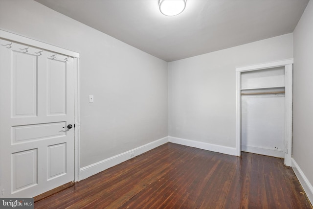 unfurnished bedroom featuring dark hardwood / wood-style flooring and a closet