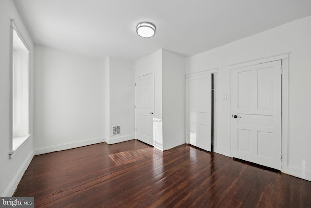 unfurnished bedroom with dark wood-type flooring