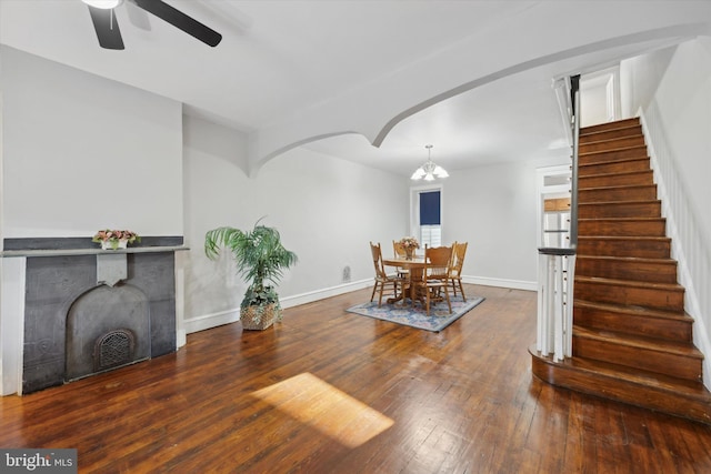 dining room featuring ceiling fan with notable chandelier and dark hardwood / wood-style floors