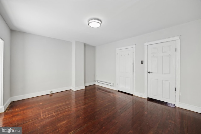 empty room featuring a baseboard radiator and dark hardwood / wood-style floors