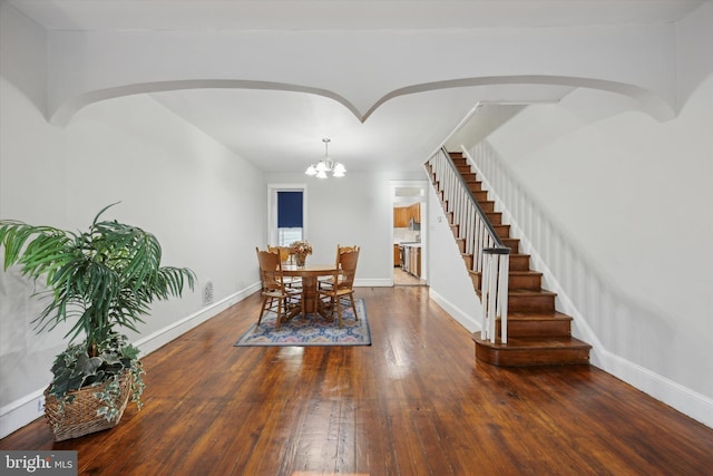 dining area with wood-type flooring and an inviting chandelier