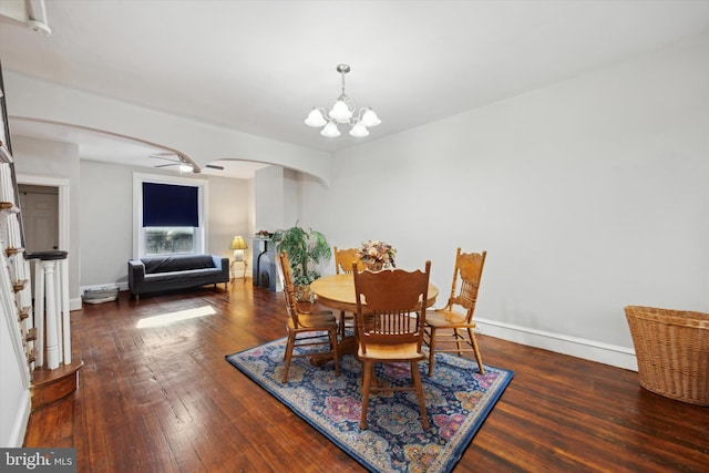 dining space featuring ceiling fan with notable chandelier and dark hardwood / wood-style floors