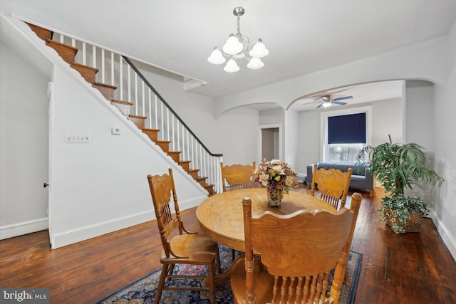 dining space featuring ceiling fan with notable chandelier and dark hardwood / wood-style flooring