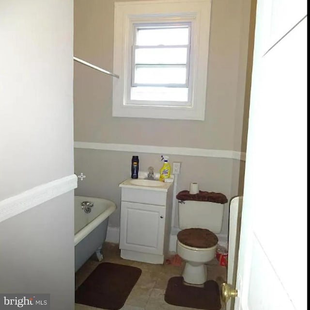 bathroom featuring vanity, toilet, and a bath