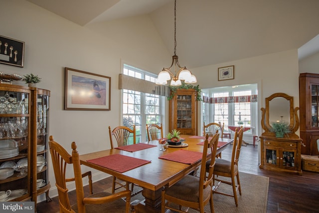 dining room with dark hardwood / wood-style floors, a healthy amount of sunlight, lofted ceiling, and a notable chandelier