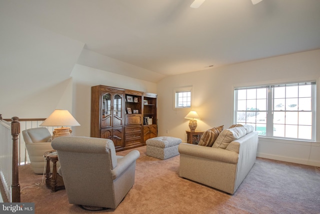 living room with a healthy amount of sunlight, light carpet, and vaulted ceiling