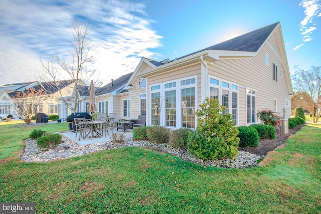 back of house with a lawn and a patio area