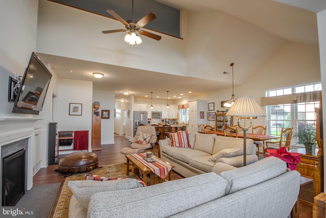 living room featuring ceiling fan, hardwood / wood-style floors, and high vaulted ceiling