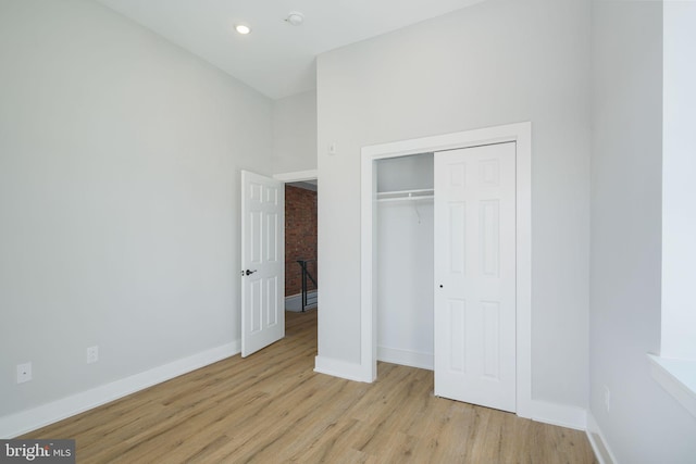 unfurnished bedroom featuring light hardwood / wood-style floors and a closet