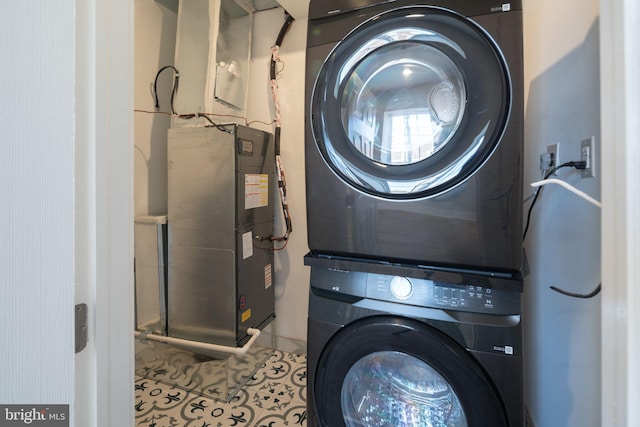 laundry room featuring tile patterned floors and stacked washer / drying machine