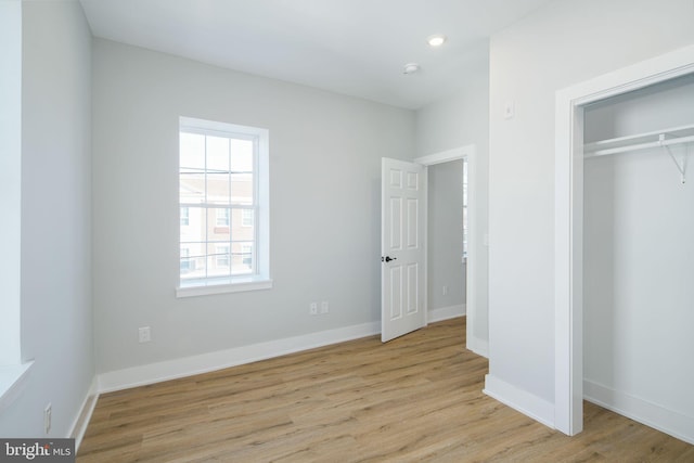 unfurnished bedroom with light hardwood / wood-style floors and a closet