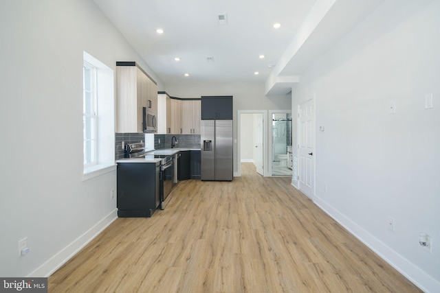 kitchen with sink, stainless steel appliances, light hardwood / wood-style flooring, decorative backsplash, and light brown cabinetry