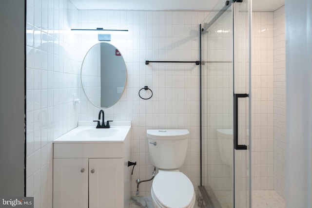 bathroom with an enclosed shower, vanity, toilet, and tile walls