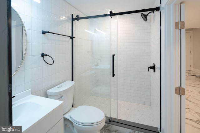 bathroom featuring vanity, a shower with shower door, tile walls, and toilet