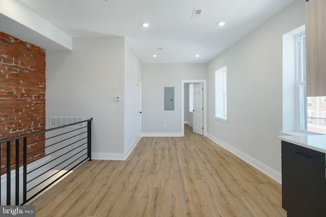 hallway with light hardwood / wood-style floors and electric panel