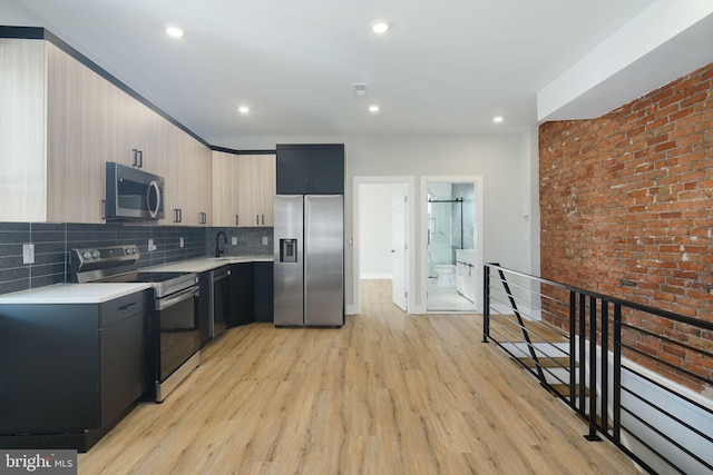 kitchen with decorative backsplash, appliances with stainless steel finishes, sink, light brown cabinets, and light hardwood / wood-style flooring