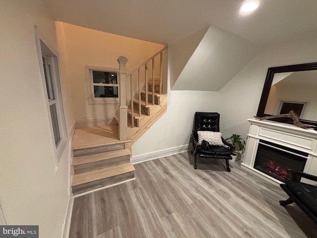 living area with vaulted ceiling and light wood-type flooring