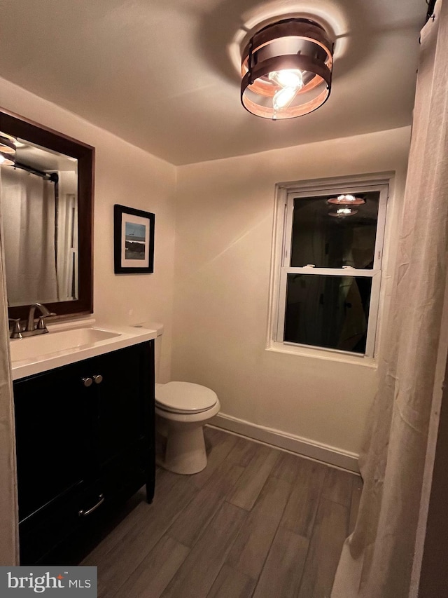 bathroom featuring vanity, toilet, and hardwood / wood-style floors