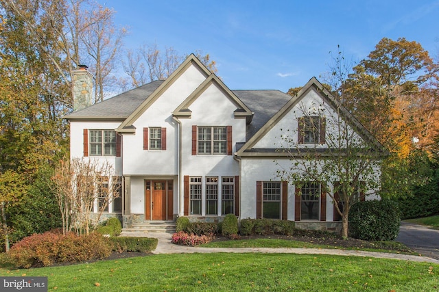 view of front of property featuring a chimney and a front lawn